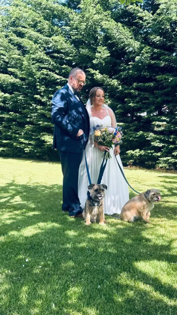 Bride and groom posing with their two dogs on their wedding day with the help of a Pets 2 Places dog wedding chaperone service