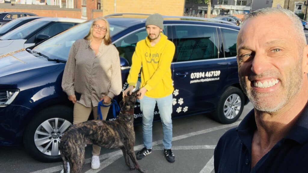 pet taxi driver with customers and their dog in front of the taxi